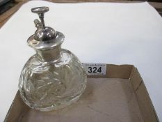 A silver topped cut glass scent bottle