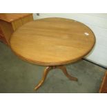 A solid oak tripod table with round top