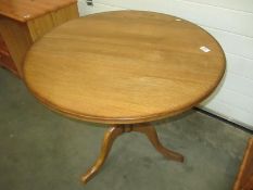 A solid oak tripod table with round top