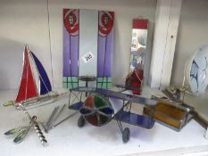 A collection of coloured glass and metal items including a wind chime, aeroplane etc.