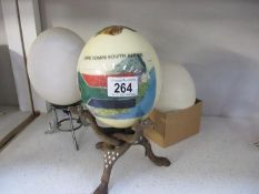 3 Ostrich eggs, 2 on stands, 1 decorated with Cape Town,