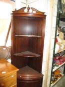 A dark wood stained corner cupboard