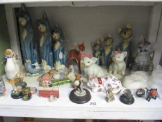 A shelf of animal figures including cats and pigs