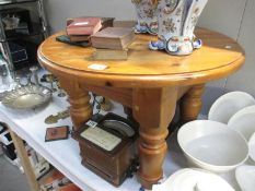 A solid pine round coffee table with chunky turned legs