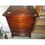 A dark wood stained bedside chest of drawers