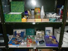 2 shelves containing a good lot of craft work items including stamps, paper etc.