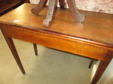 An Edwardian mahogany fold over card/tea table with cross banded top