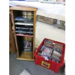 A box of cd's and a dvd rack containing some dvds