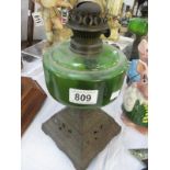 A Victorian oil lamp with green glass font