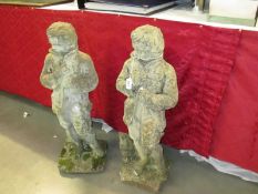 A pair of 'Boy in coat' garden statues,