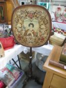 A Victorian mahogany pole screen on tripod base and with tapestry panel