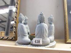 A candle holder in the form of 5 Buddhas in a circle