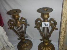 A pair of brass lyre candlesticks