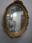 A gilt framed oval mirror