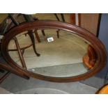 An oval wood framed mirror