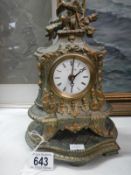 An ornate mantel clock surmounted by a cherub