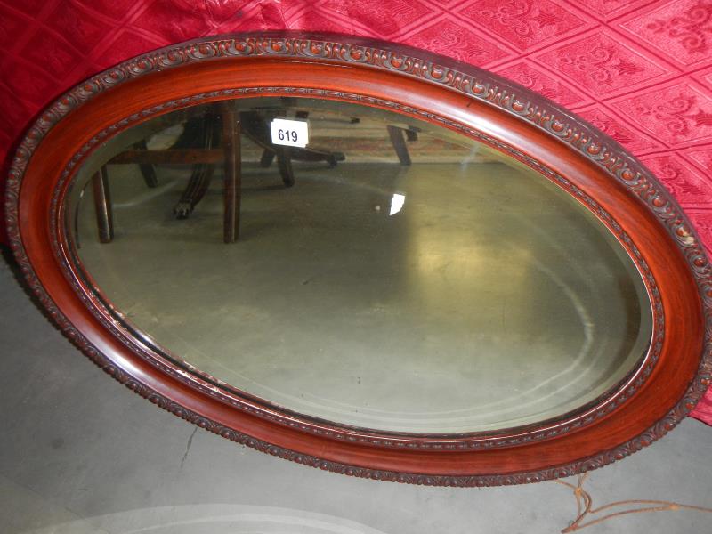 An oval wood framed mirror