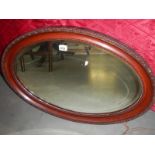 An oval wood framed mirror