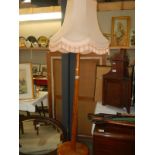 A wooden standard lamp and shade