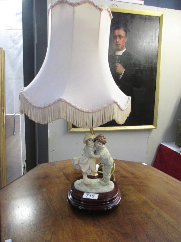 A figural lamp featuring a boy and girl with shade