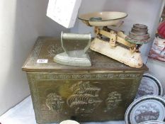 A brass and wooden log box featuring nautical panels,