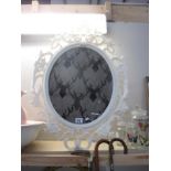 An ornate oval white frame