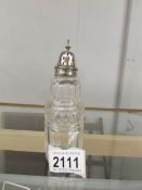 A glass sugar sifter with silver top.