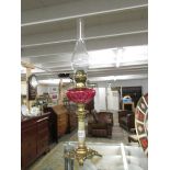 A Victorian Corinthian column oil lamp with cranberry glass font.