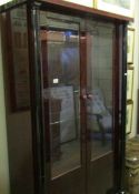 A modern dark wood stained display cabinet.