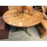 A solid oak tripod tea table