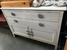 A white painted shabby chic chest of drawers with cupboards