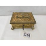 An early 20th century gilded metal box with silk lining and complete with key.