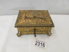 An early 20th century gilded metal box with silk lining and complete with key.