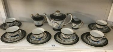 A Japanese dragon tea set with geisha face to bottom of cups