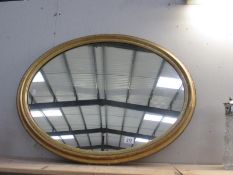 A large oval gilt framed mirror