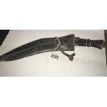 A kukri in white metal sheath with skinning knives