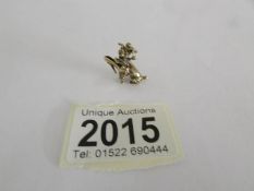 A 9ct gold charm in the form of a dog carrying a shoe, approximately 5 grams.