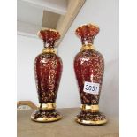 A pair of ruby glass vases decorated with gilding,