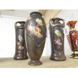 A pair of Bretby bird decorated vases and one other.