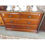 A 2 over 2 mahogany chest of drawers with protective glass top.