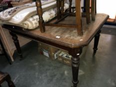 An Edwardian mahogany extending dining table with 1 leaf