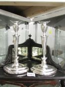 A pair of tall silver candlesticks on oval bases, hall marked for Sheffield 1918/19, Maker H.E Ltd.