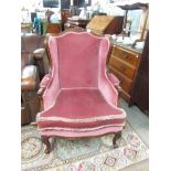 A pink upholstered wing arm chair.