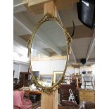 An oval gilt framed mirror.