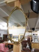 An oval gilt framed mirror.
