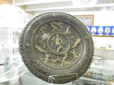 A large metal plaque with classical depictions.