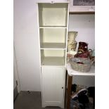 A white finished bathroom shelf unit with cupboard