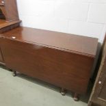 An Edwardian mahogany drop side dining table on pad feet.