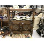 A dark oak tea trolley with cupboard underneath