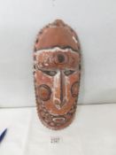 A Papua New Guinea mask: a carved wood tribal mask from Papua New Guinea with inset cowrie shell